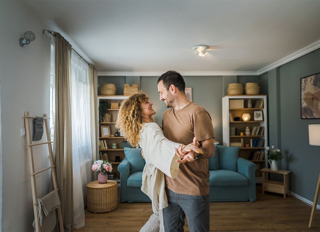 Read Our Reviews - Cheerful Young Couple Dancing in the Living Room of Their New Apartment